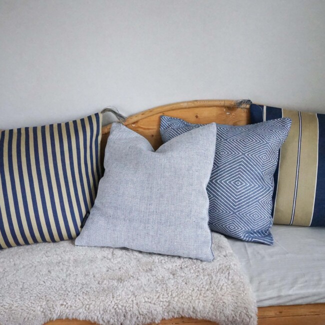 Linen cushions from Klässbols Linneväveri in blue tones in a kitchen sofa.